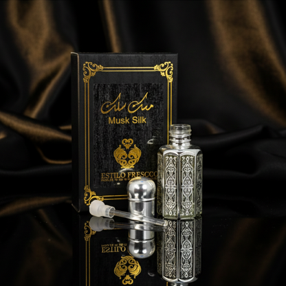 Perfume bottle and packaging with intricate design on a dark fabric background